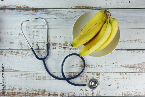 Konstfotografi Selective focus of bunch of bananas and stethoscope.