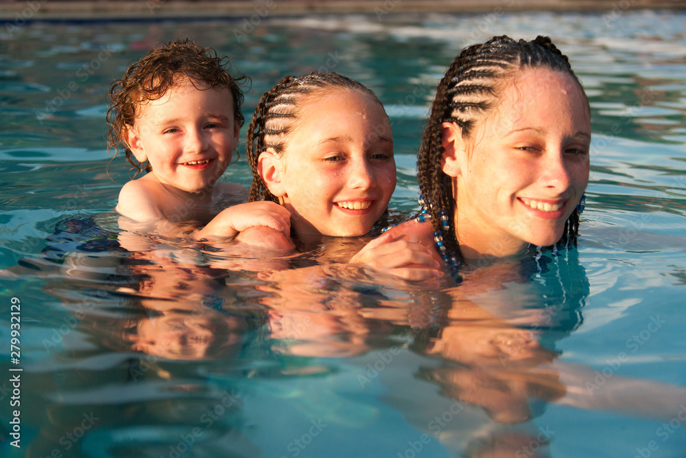 Three children playing piggyback while swimming in a pool in Cruz Bay, St. John, USVI Three children playing piggyback while swimming in a pool in Cruz Bay, St. John, USVI