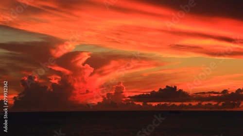 Dramatic clouds over sea at orange dusk photo