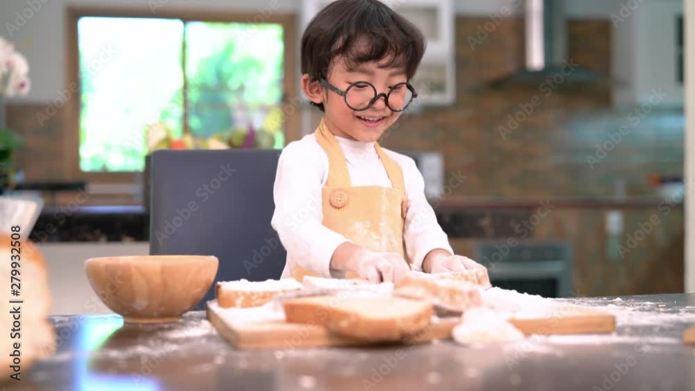 Pastry chef asian little boy making bakery bread cookie and cake delicious sweet food funny moment enjoy in the kitchen room at home Pastry chef asian little boy making bakery bread cookie and cake delicious sweet food funny moment enjoy in the kitchen room at home