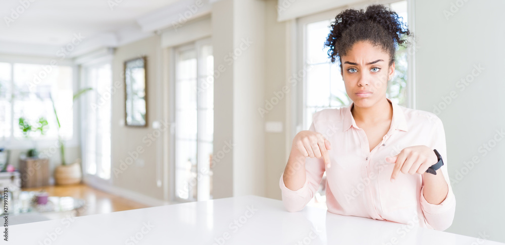 © Krakenimages.com - Wide angle of beautiful african american woman with afro hair Pointing down looking sad and upset, indicating direction with fingers, unhappy and depressed. © Krakenimages.com - Wide angle of beautiful african american woman with afro hair Pointing down looking sad and upset, indicating direction with fingers, unhappy and depressed.