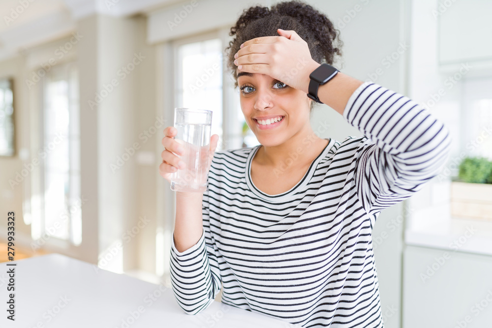 Young african american girl drinking a fresh glass of water stressed with hand on head, shocked with shame and surprise face, angry and frustrated. Fear and upset for mistake. Young african american girl drinking a fresh glass of water stressed with hand on head, shocked with shame and surprise face, angry and frustrated. Fear and upset for mistake.