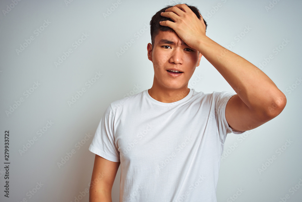 Young asian chinese man wearing t-shirt standing over isolated white background surprised with hand on head for mistake, remember error. Forgot, bad memory concept. Young asian chinese man wearing t-shirt standing over isolated white background surprised with hand on head for mistake, remember error. Forgot, bad memory concept.