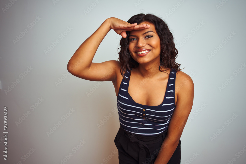 Transsexual transgender woman wearing striped t-shirt over isolated white background very happy and smiling looking far away with hand over head. Searching concept.