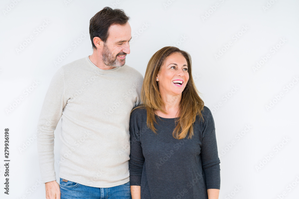 Beautiful middle age couple in love over isolated background looking away to side with smile on face, natural expression. Laughing confident. Beautiful middle age couple in love over isolated background looking away to side with smile on face, natural expression. Laughing confident.