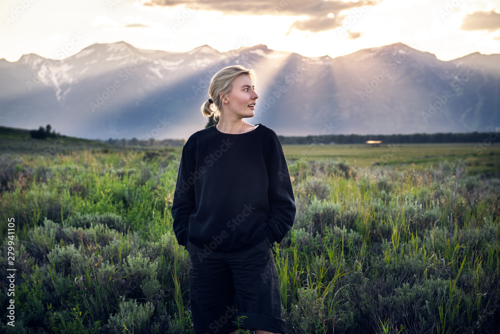 Beautiful tourist woman traveling and enjoy the nature mountain view in green field on a summertime vacation in Yellowstone National Park Beautiful tourist woman traveling and enjoy the nature mountain view in green field on a summertime vacation in Yellowstone National Park