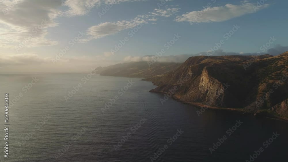 Aerial shot flying next to grand coastline at sunrise. Cliffs and steep hills by the ocean in southern California. Aerial shot flying next to grand coastline at sunrise. Cliffs and steep hills by the ocean in southern California.