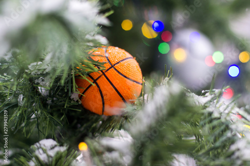 Basketball ball toy on the branches of an artificial fir-tree.