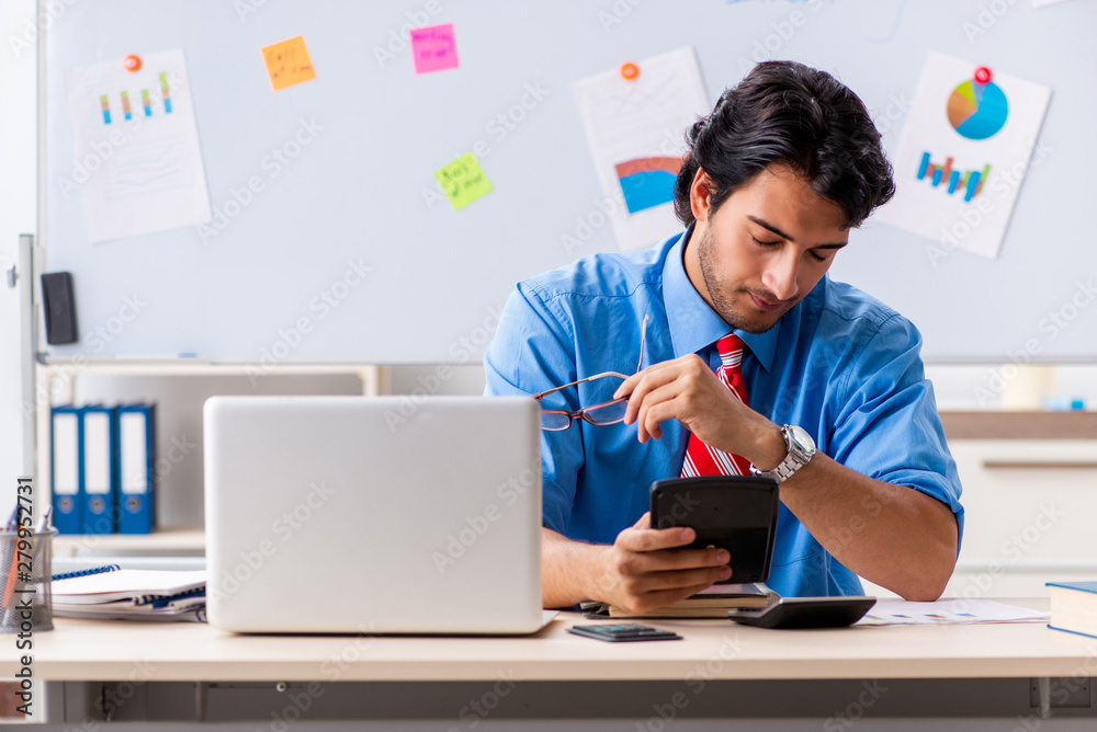 Young male financial manager working in the office Young male financial manager working in the office