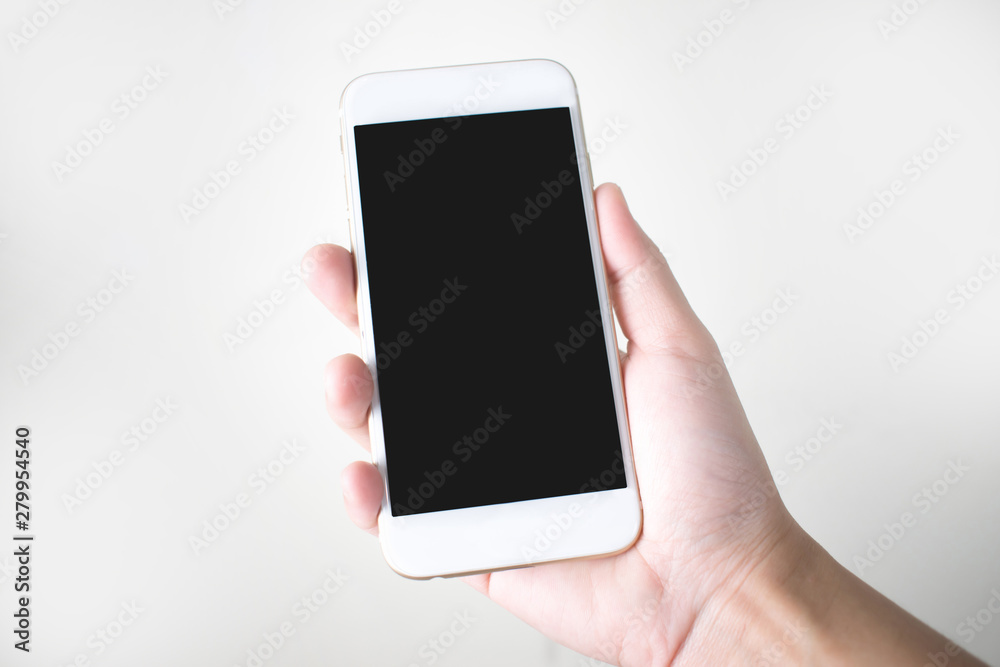 Young hands holding a smart phone on a white background Young hands holding a smart phone on a white background