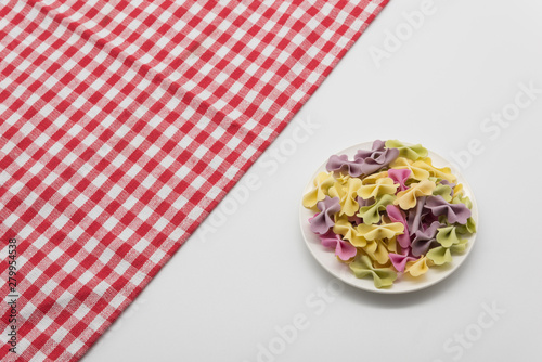 Fototapeta Naklejka Na Ścianę i Meble -  A plate of childA plate of children's colored butterfly face placed on a red and whren's colored butterfly face placed on a red and white gingham diagonal background, Italian style catering background