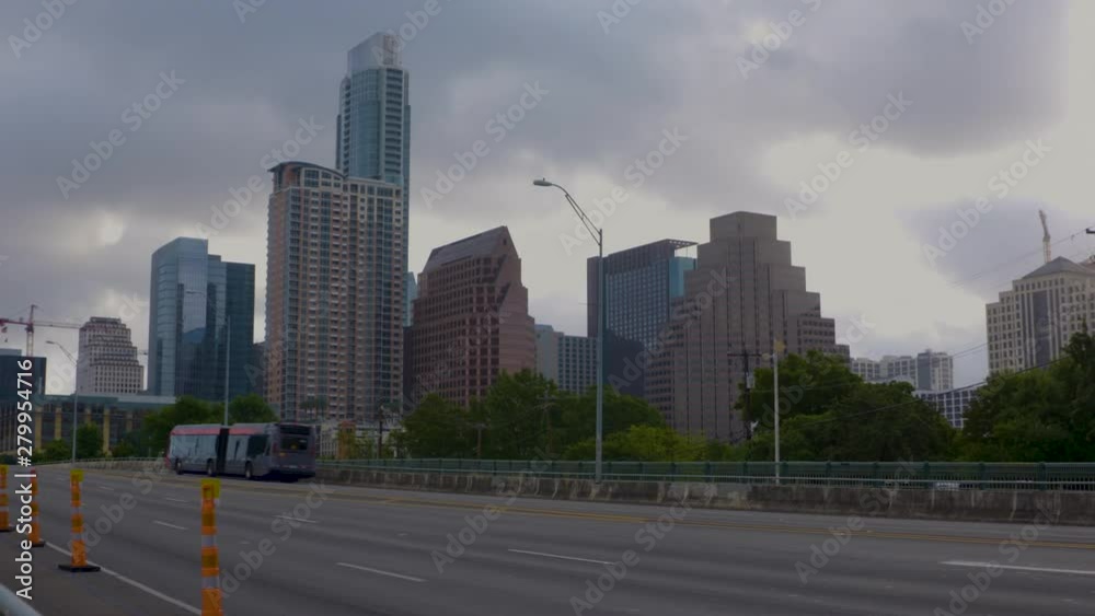 Cars pass over bridge in front of Austin, Texas skyline (1080) Cars pass over bridge in front of Austin, Texas skyline (1080)