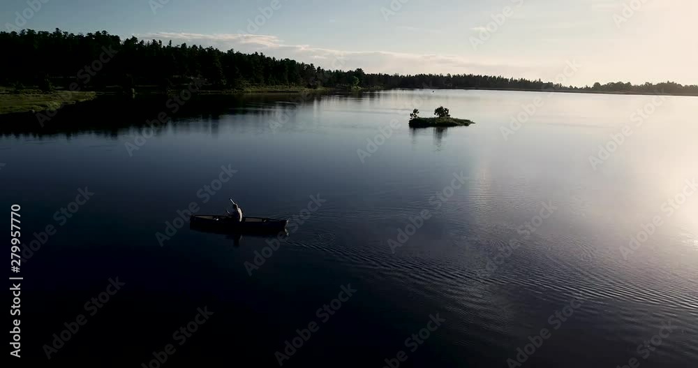 High mountain lake being navigated by a canoe. 4k drone shot at 60fps for increased editing options. High mountain lake being navigated by a canoe. 4k drone shot at 60fps for increased editing options.