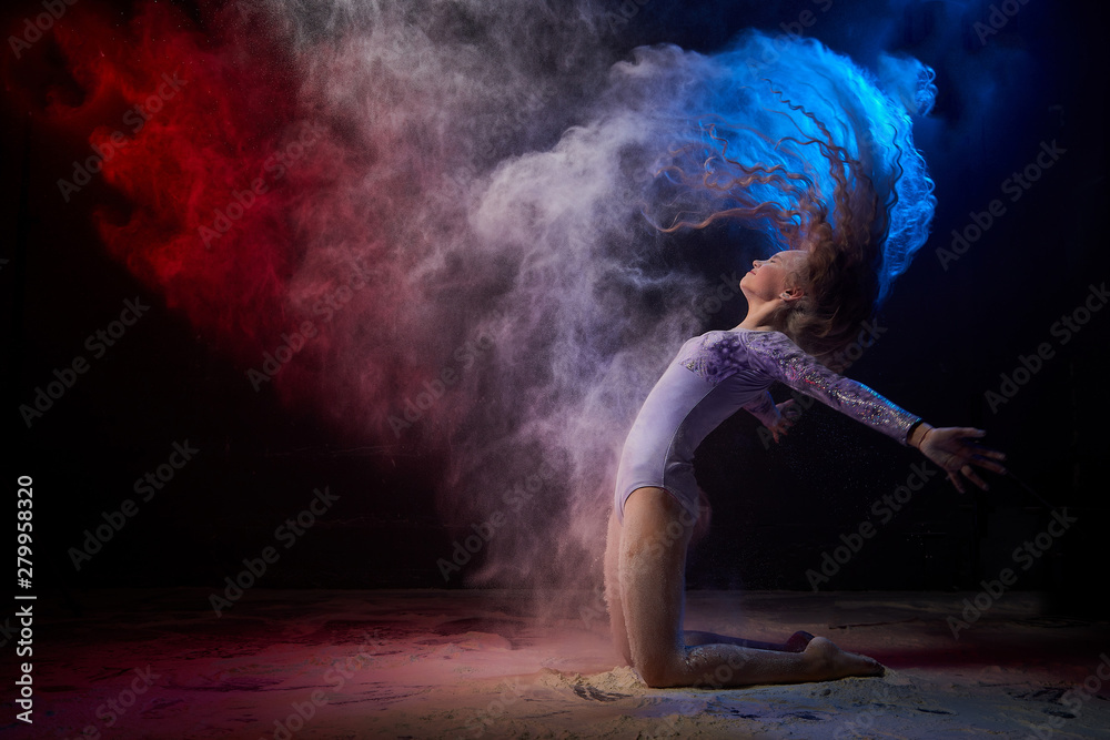 Beautiful teen girl with long blonde curly hair in a dark room with colored lights and clouds of flour