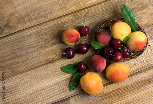 Apricot, Peach, Cherry berries on wood background.