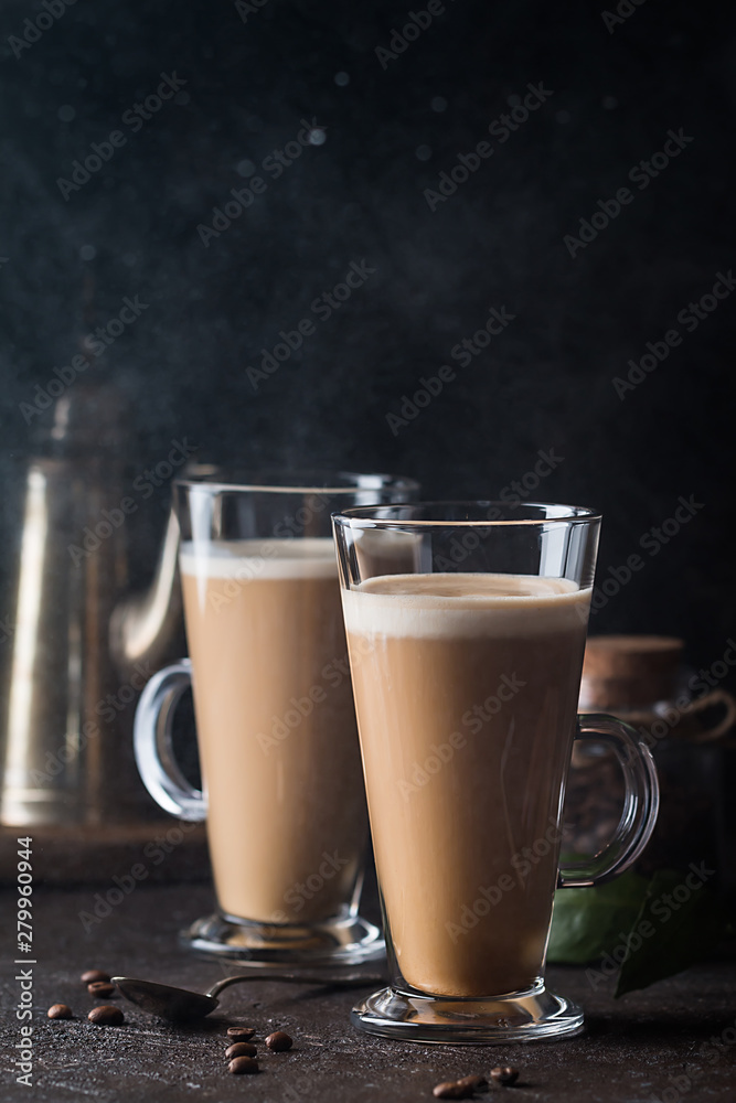 Two glasses with cold coffee latte macchiato on table against black background Two glasses with cold coffee latte macchiato on table against black background