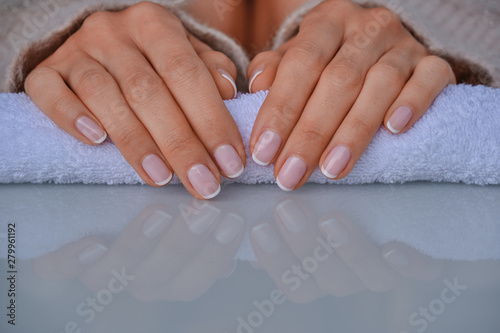 Ideally made manicure and pedicure. Female legs and hands on a marble with flowers