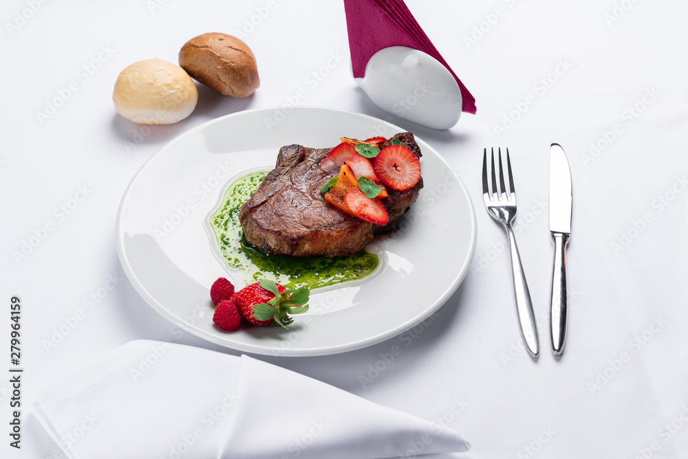 beef stake with strawberry on white dish and basil saus beef stake with strawberry on white dish and basil saus