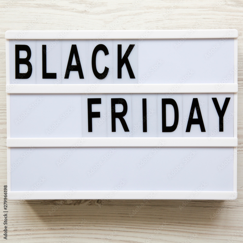 'Black Friday' words on a modern board on a white wooden background. Flat lay, overhead, from above. Close-up. 'Black Friday' words on a modern board on a white wooden background. Flat lay, overhead, from above. Close-up.