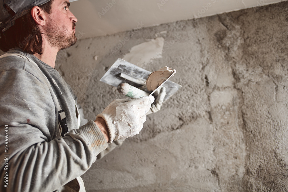 Construction worker plastering gypsum walls inside the house. Construction worker plastering gypsum walls inside the house.