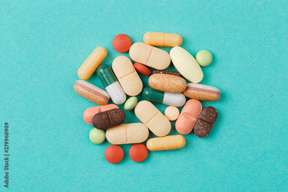 colour tablets and pills on blue background . colour tablets and pills on blue background .