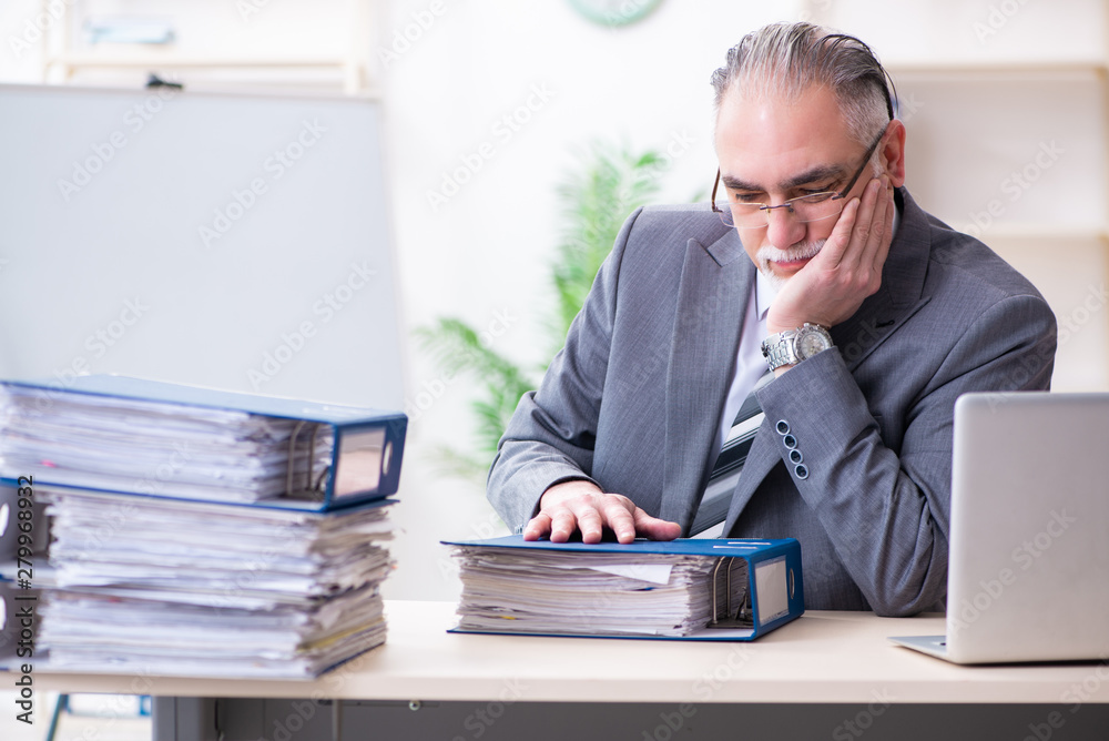 Aged male employee unhappy with excessive work Aged male employee unhappy with excessive work
