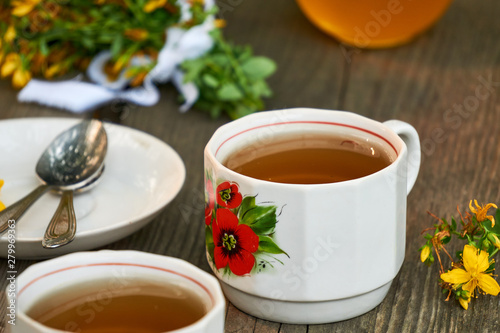 A cup of hypericum tea on a wooden background 