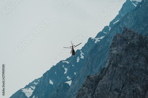 Helicopter flying besides mountains in Badrinath, Uttarakhand, India photo