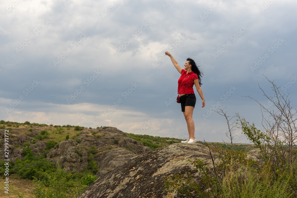 Large granite canyon. Village Aktove. Ukraine. Beautiful stone landscape. Woman 35 years old brunette tourist on the canyon. Large granite canyon. Village Aktove. Ukraine. Beautiful stone landscape. Woman 35 years old brunette tourist on the canyon.
