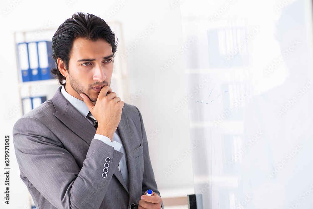 Young handsome businessman in front of whiteboard Young handsome businessman in front of whiteboard
