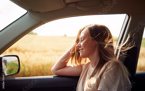 Obraz na plátně Dreaming woman traveling by car