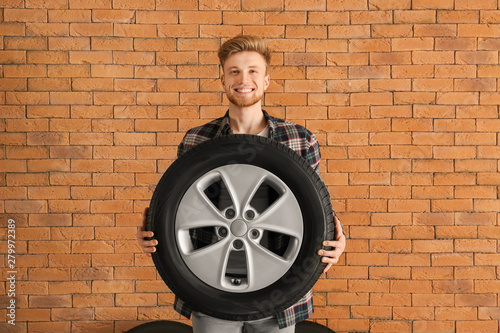 Young man with car tire nea...
