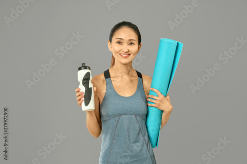Sporty Asian woman with mat...
