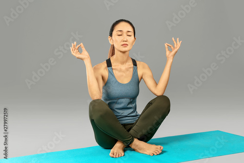 Asian woman practicing yoga...