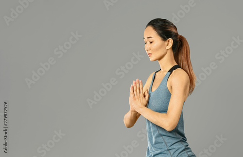 Asian woman practicing yoga...