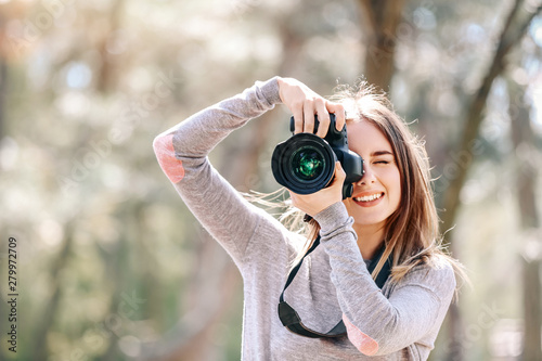 Beautiful female photographer working outdoors photo