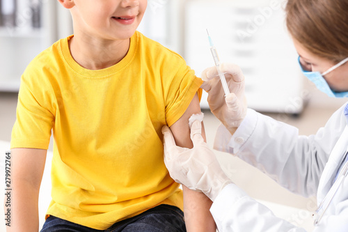 Doctor vaccinating little b...