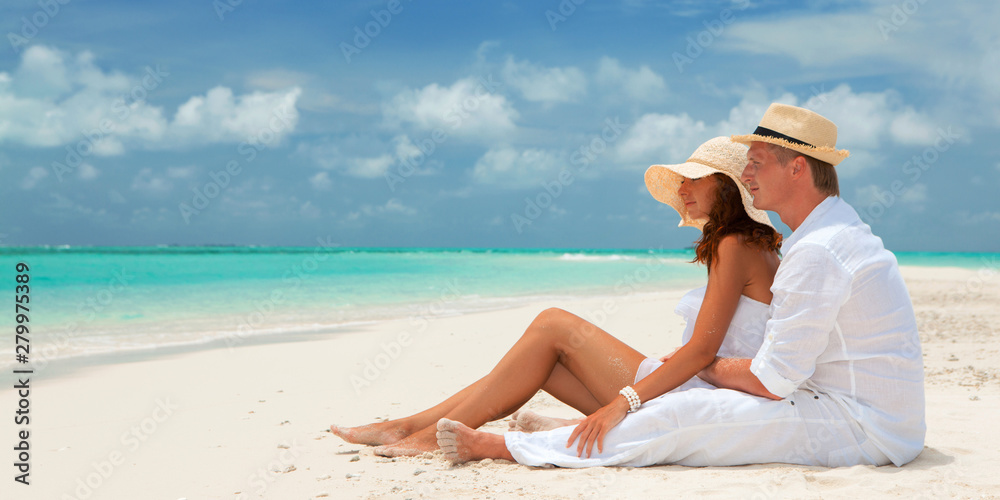 Happy honeymoon vacation at summer. Couple relax on the white sand of beach. Happy sea lifestyle. Young family, man and woman rest on the beach of ocean. Couple in love travel to island. Love travel