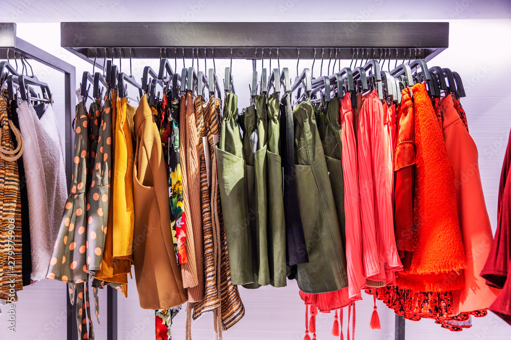 Women's clothing on rail in the store. Skirts of different colors and textures. Close-up.