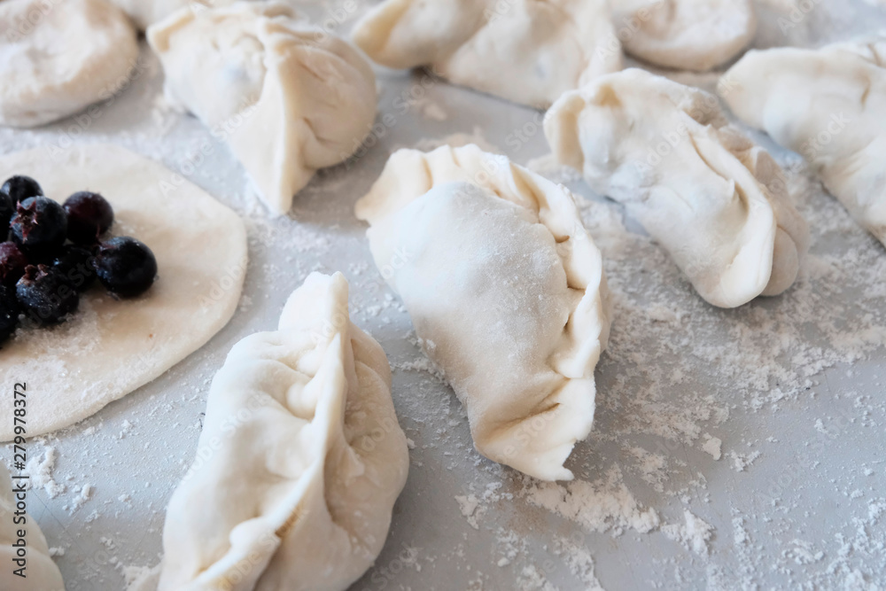 Dumplings, dumplings, ravioli, filled with cherries, berries. Pies-dumplings with filling, a popular dish in many countries. The concept of cooking sweet dishes , desserts.