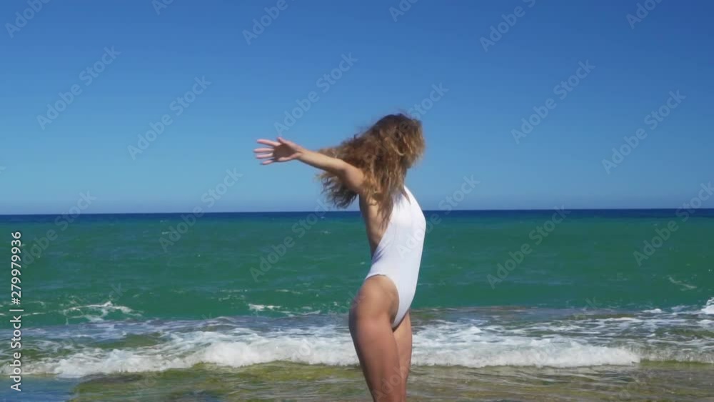 Aerial view. Slender woman dancing on rocky sea beach. Aerial view. Slender woman dancing on rocky sea beach.