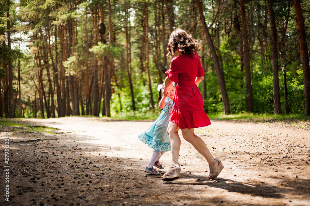 cute little girl and her mother having fun on the grass in a Sunny Park