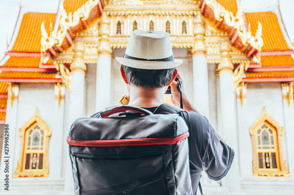 Obraz premium Asian man tourist taking photo with camera at Wat Benchamabophit Dusitvanaram Bangkok Thailand. Travelers take pictures with DSLR cameras. Asia tourist, Thailand. .