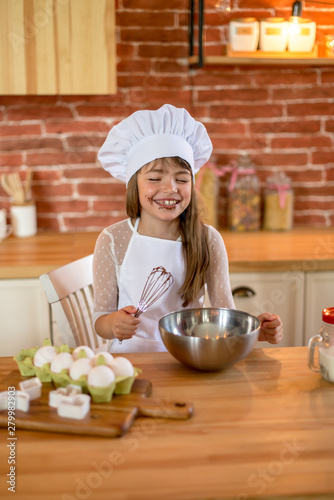 Funny chef girl cooking at kitchen. Girl of school age. Homemade food concept.