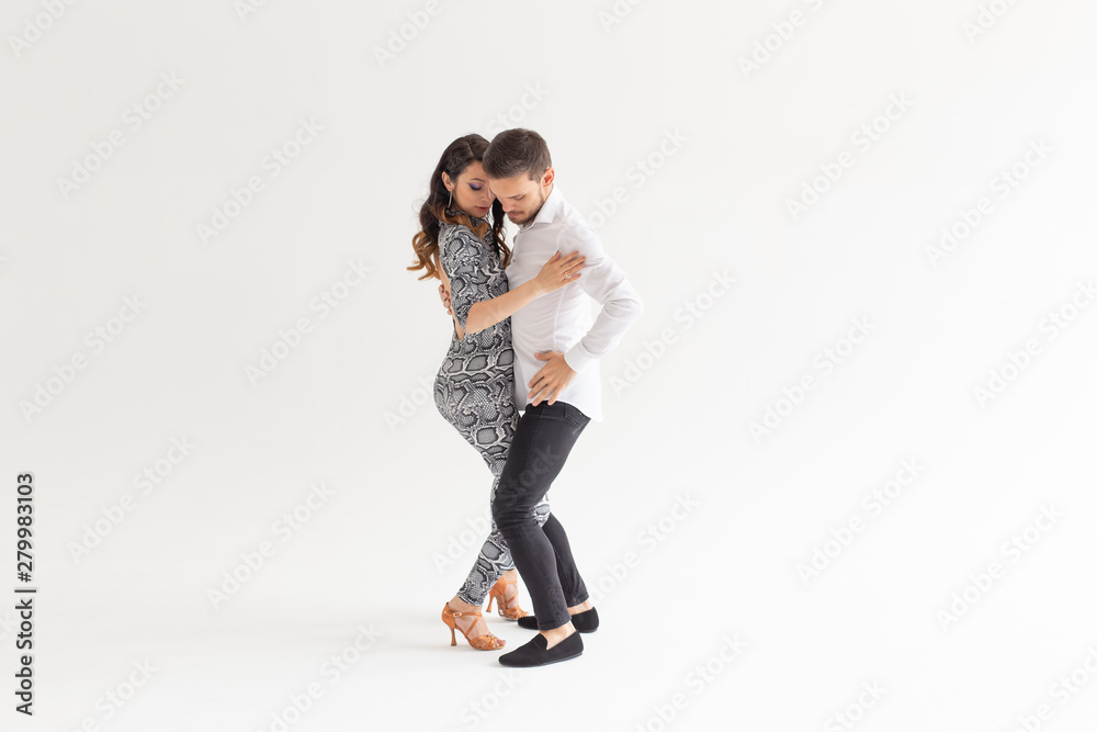 Social dance, bachata, kizomba, zouk, tango concept - Man hugs woman while dancing over white background with copy space Social dance, bachata, kizomba, zouk, tango concept - Man hugs woman while dancing over white background with copy space