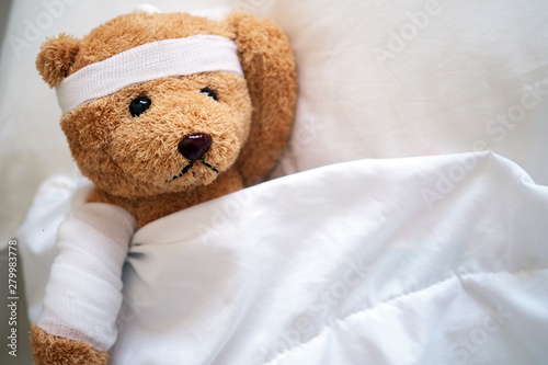 The teddy bear is sore, broken arm and broken head in the bedroom.