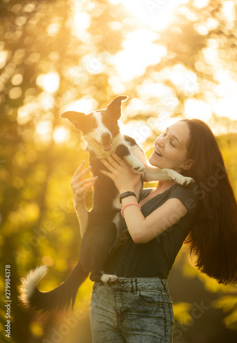 girl playing with a dog in the forest