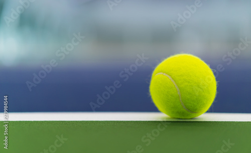 one new tennis ball on white line in blue and green hard court with copy space on left © angyim