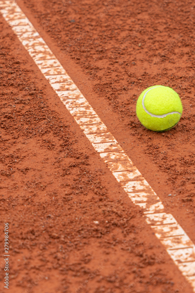 Tennis ball lying near white line on tennis court background
