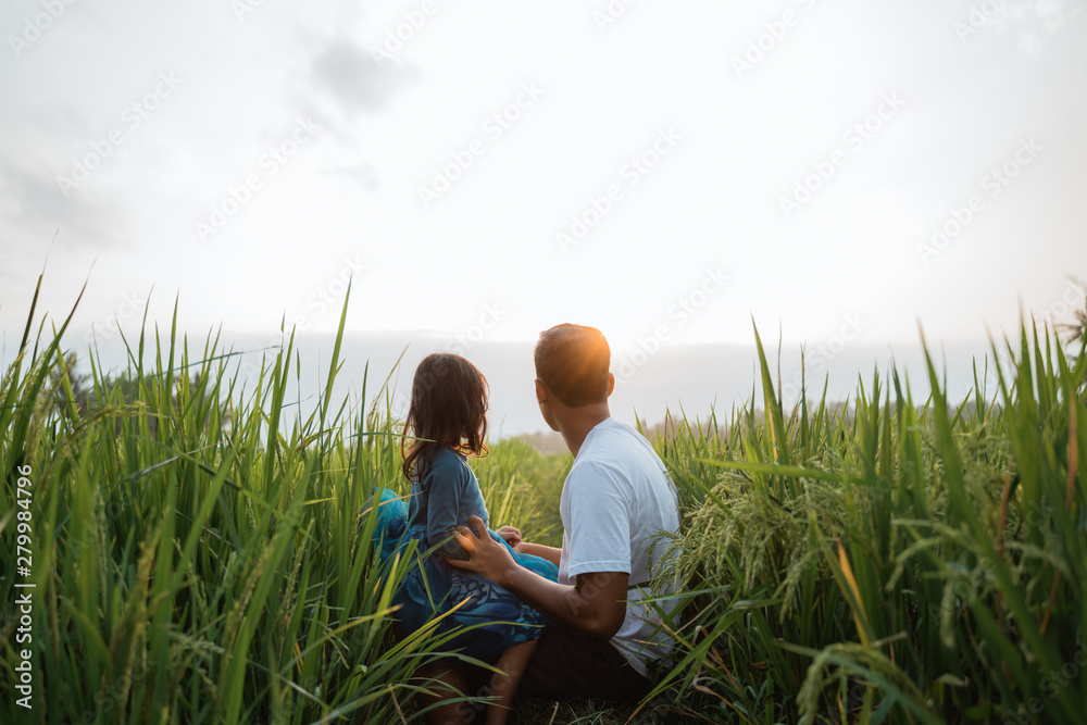 daughter and father bonding outdoor enjoy in the rice field playing and embracing each other daughter and father bonding outdoor enjoy in the rice field playing and embracing each other
